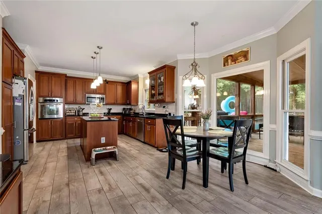 a kitchen with stainless steel appliances granite countertop a refrigerator a sink dishwasher a stove and a refrigerator