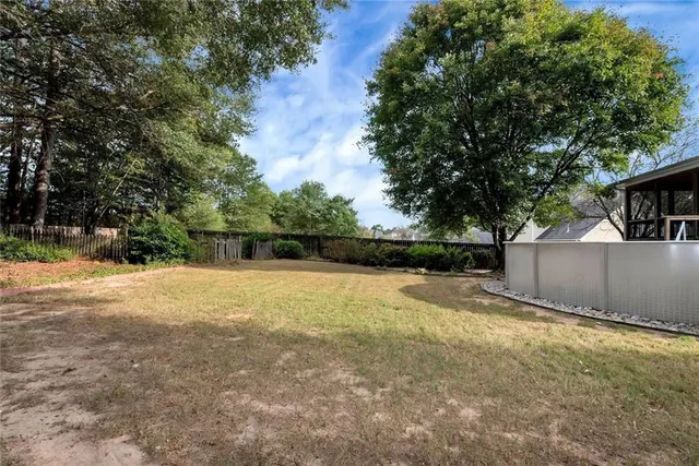 a view of a house with a yard and large trees