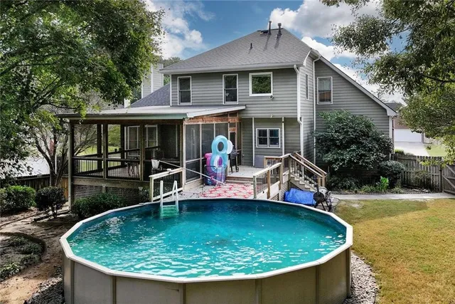 a view of a house with swimming pool next to a yard
