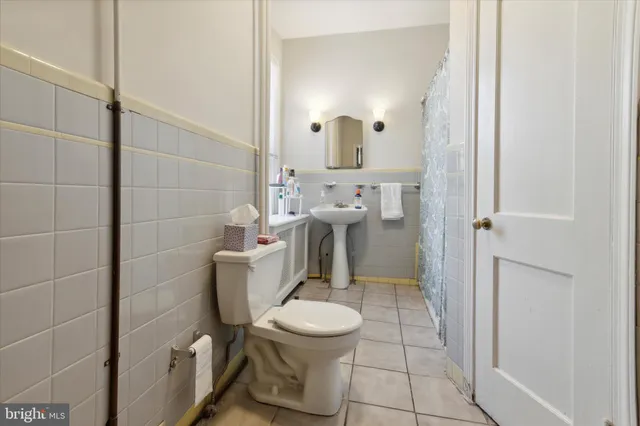 a bathroom with a toilet a sink and mirror