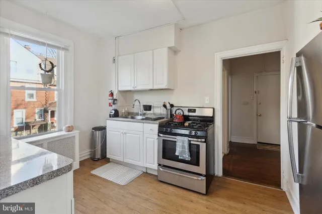 a kitchen with stainless steel appliances granite countertop a stove a sink and a refrigerator