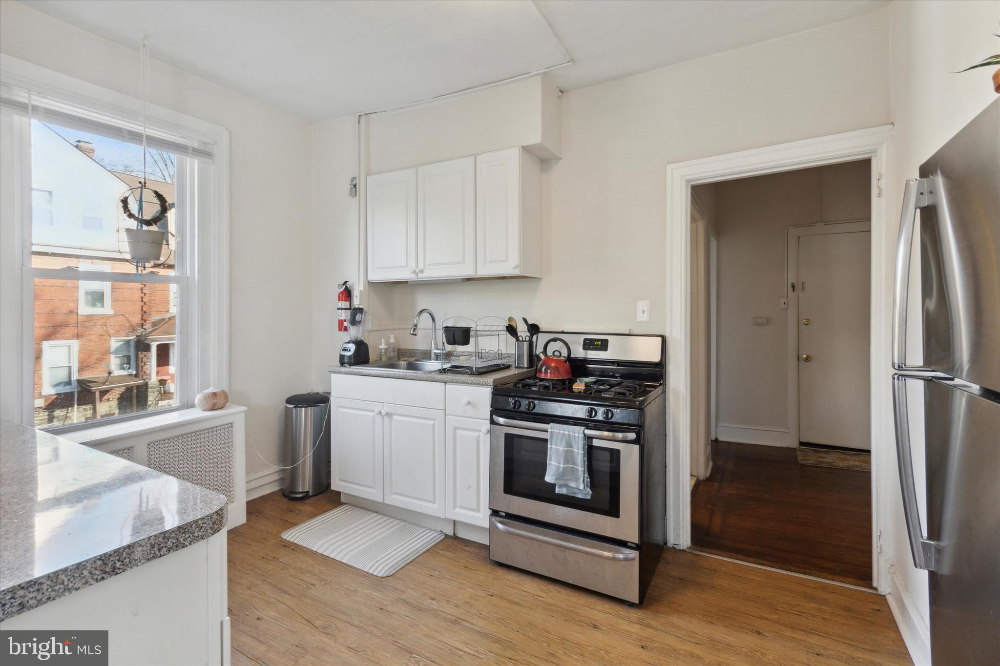 118 Walnut Avenue, Unit 2 Ardmore, PA 19003 - Photo 7 of 15 a kitchen with stainless steel appliances granite countertop a stove a sink and a refrigerator