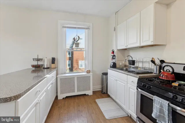 a kitchen with stainless steel appliances granite countertop a sink stove and cabinets