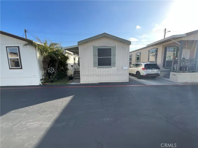 a view of a house with backyard and parking