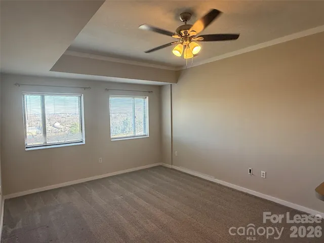 an empty room with a window and a ceiling fan
