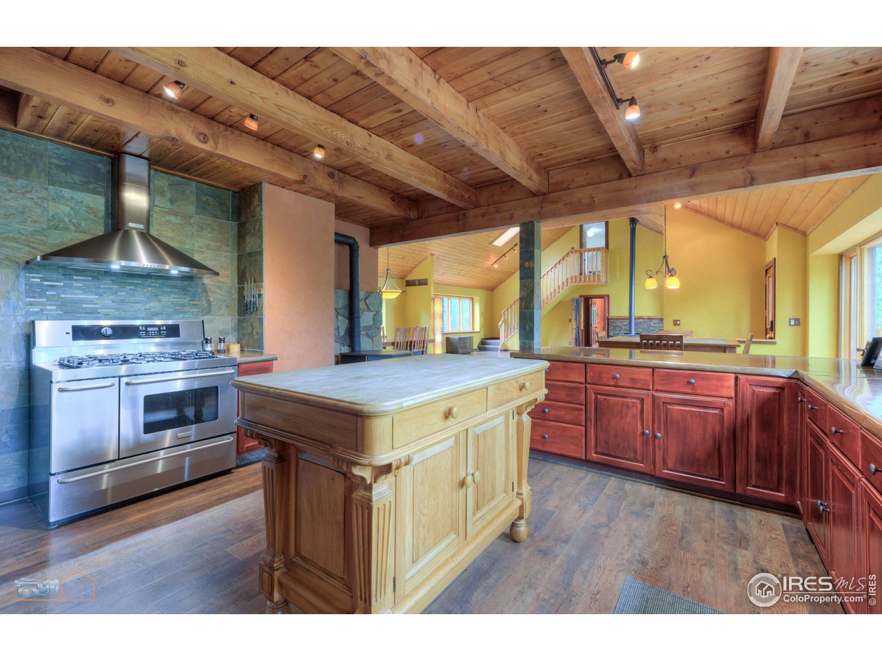 a kitchen with a stove and a microwave oven with wooden floor