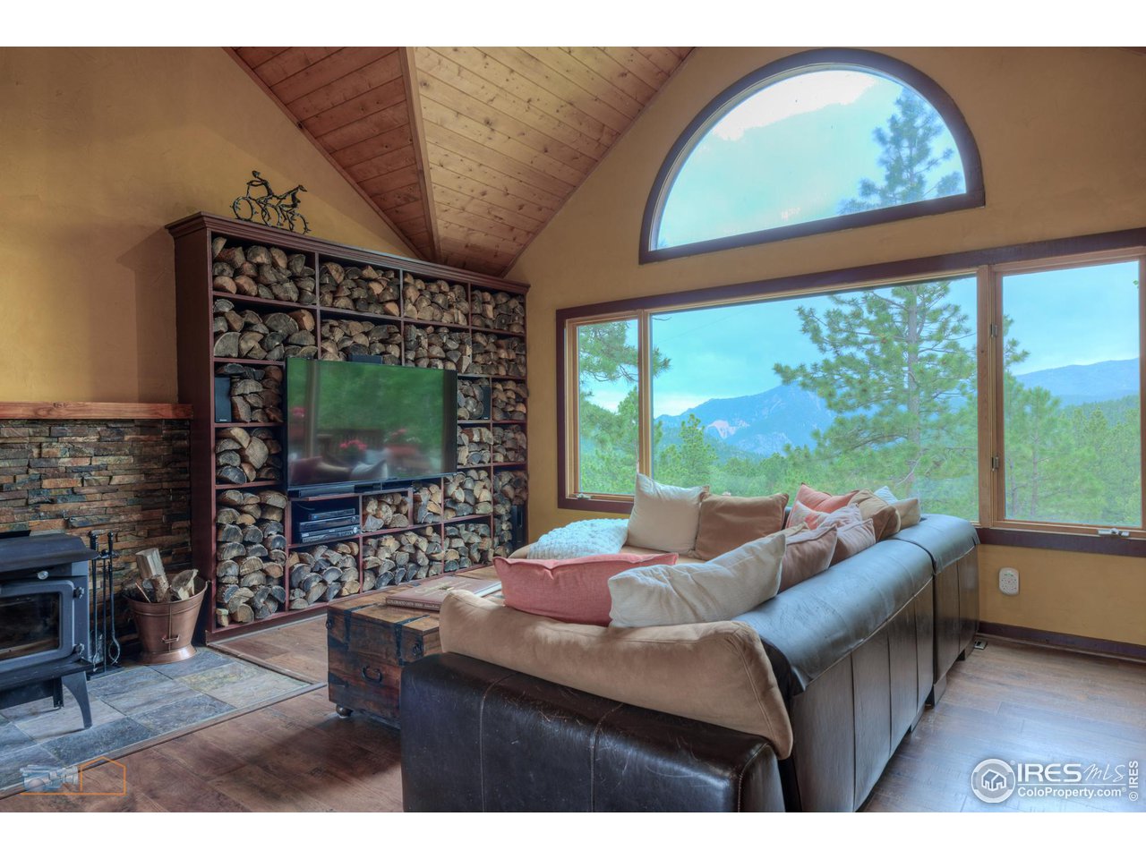 111 Puma Drive Boulder, CO 80302 - Photo 10 of 37 a living room with furniture a flat screen tv and a floor to ceiling window