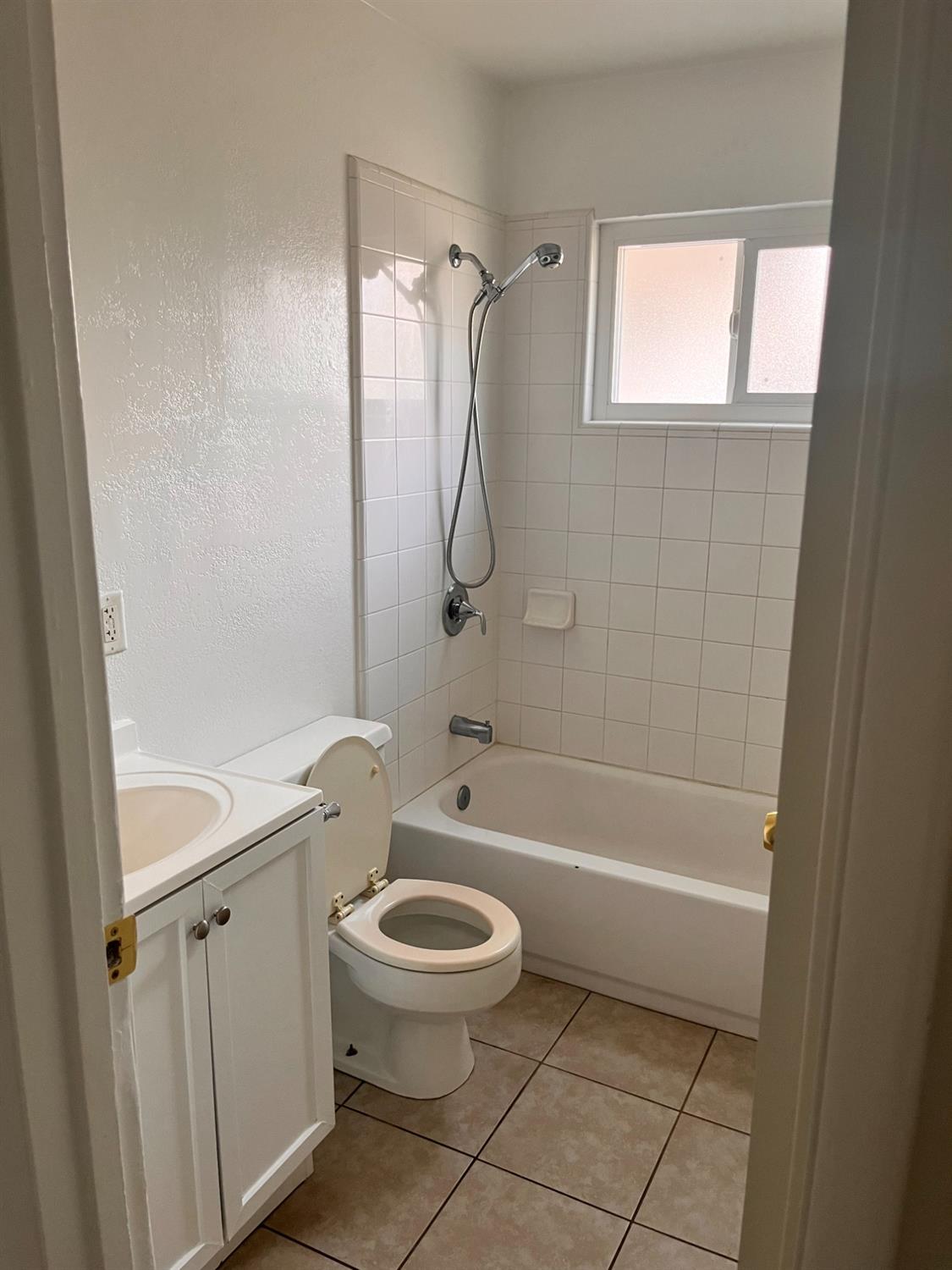 1097 Jefferson Avenue Clovis, CA 93612 - Photo 7 of 11 a bathroom with a granite countertop toilet a sink and shower