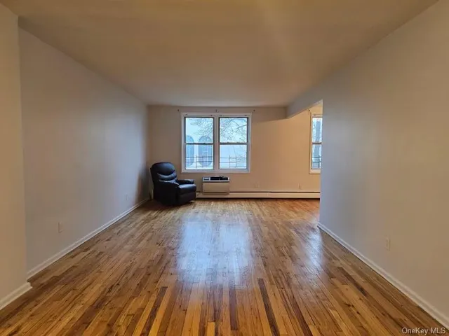 a big room with wooden floor and windows