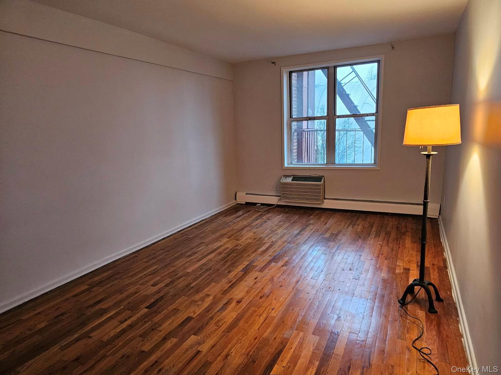 151-05 Cross Island Parkway, Unit 3E Queens, NY 11357 - Photo 14 of 29 an empty room with wooden floor and windows