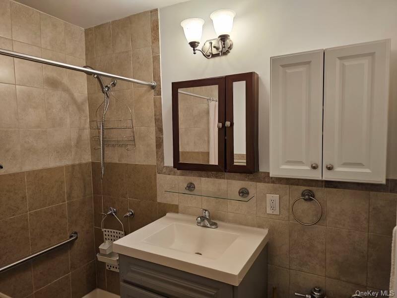 151-05 Cross Island Parkway, Unit 3E Queens, NY 11357 - Photo 15 of 29 a bathroom with a sink a toilet and a mirror