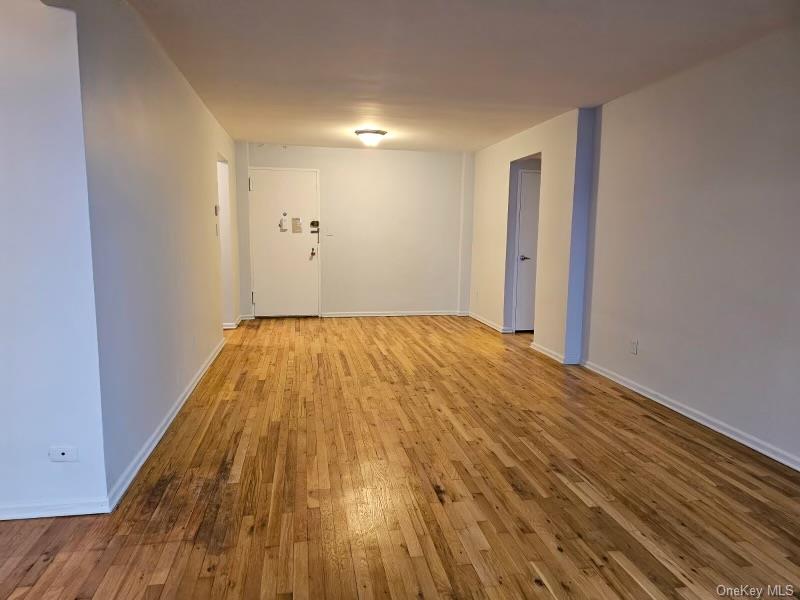 151-05 Cross Island Parkway, Unit 3E Queens, NY 11357 - Photo 8 of 29 a view of a room with wooden floor and white walls