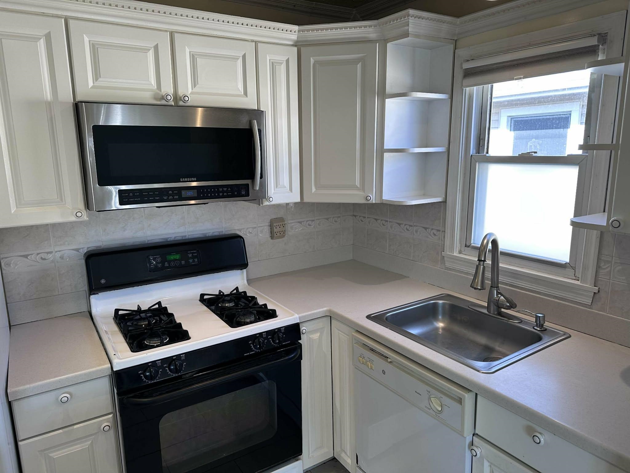 67 Country Village Road, Unit 2 Jersey City, NJ 07305 - Photo 11 of 20 a kitchen with a stove and a microwave