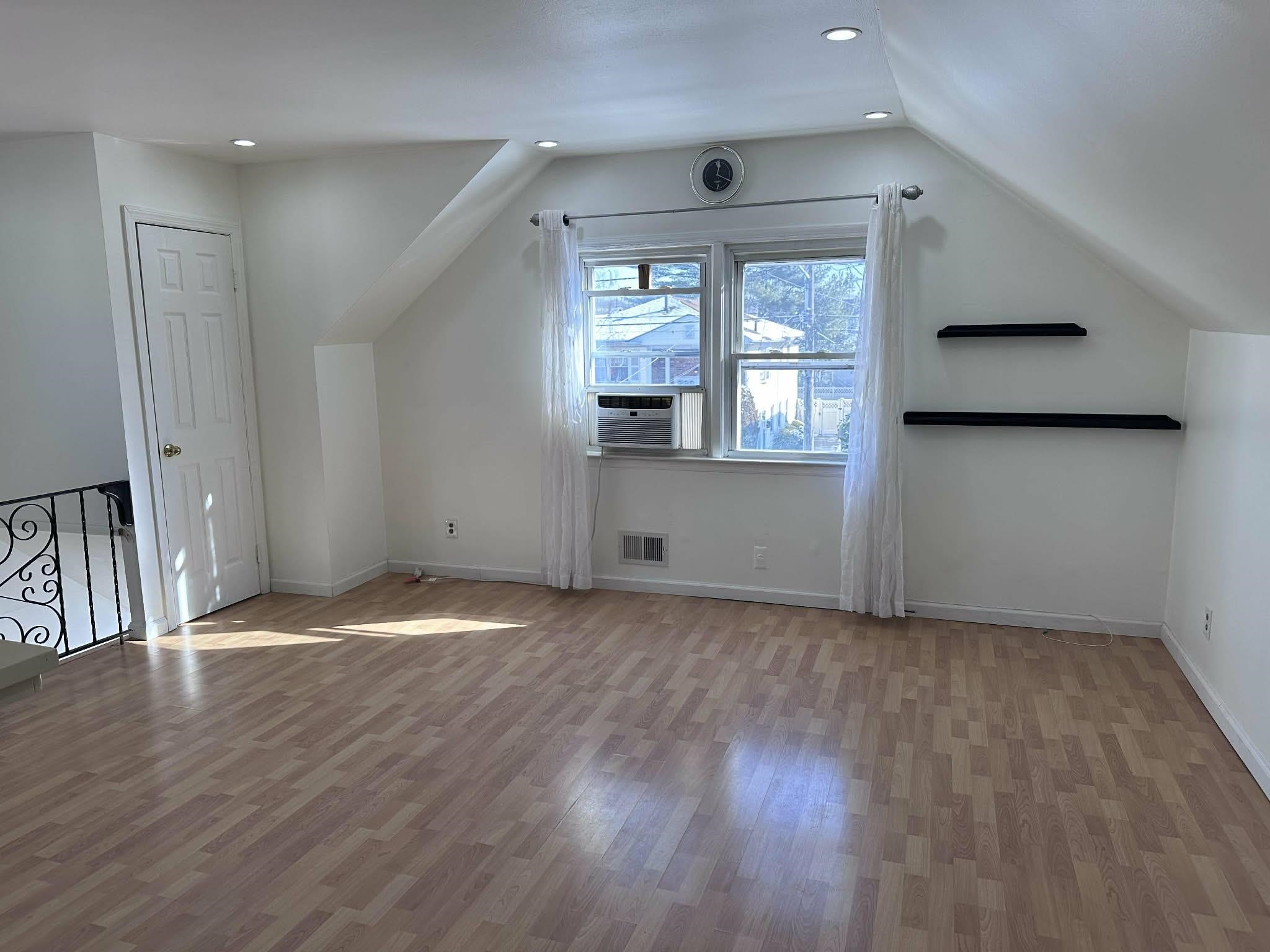 67 Country Village Road, Unit 2 Jersey City, NJ 07305 - Photo 2 of 20 an empty room with wooden floor and windows