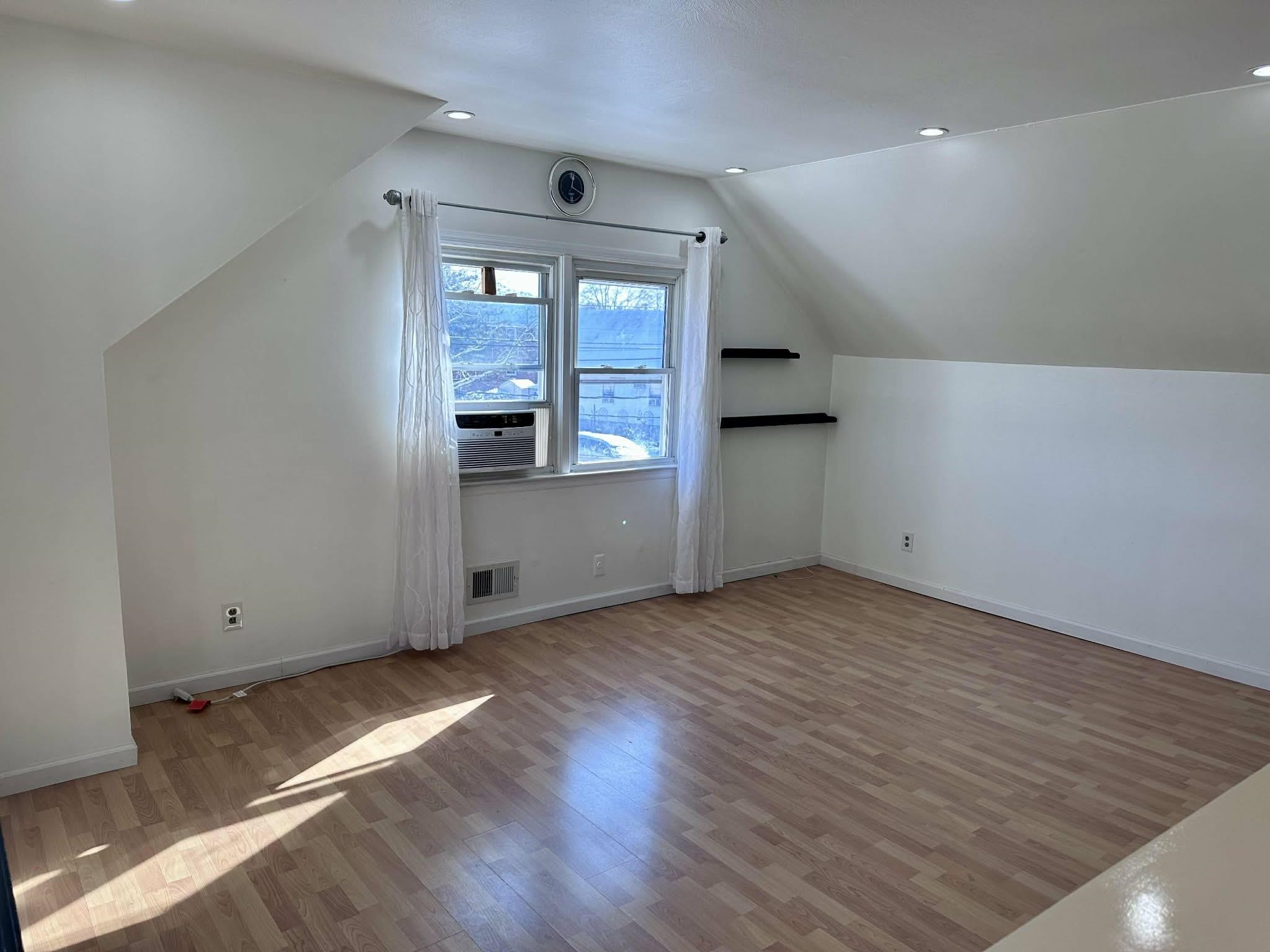 67 Country Village Road, Unit 2 Jersey City, NJ 07305 - Photo 3 of 20 an empty room with wooden floor and windows