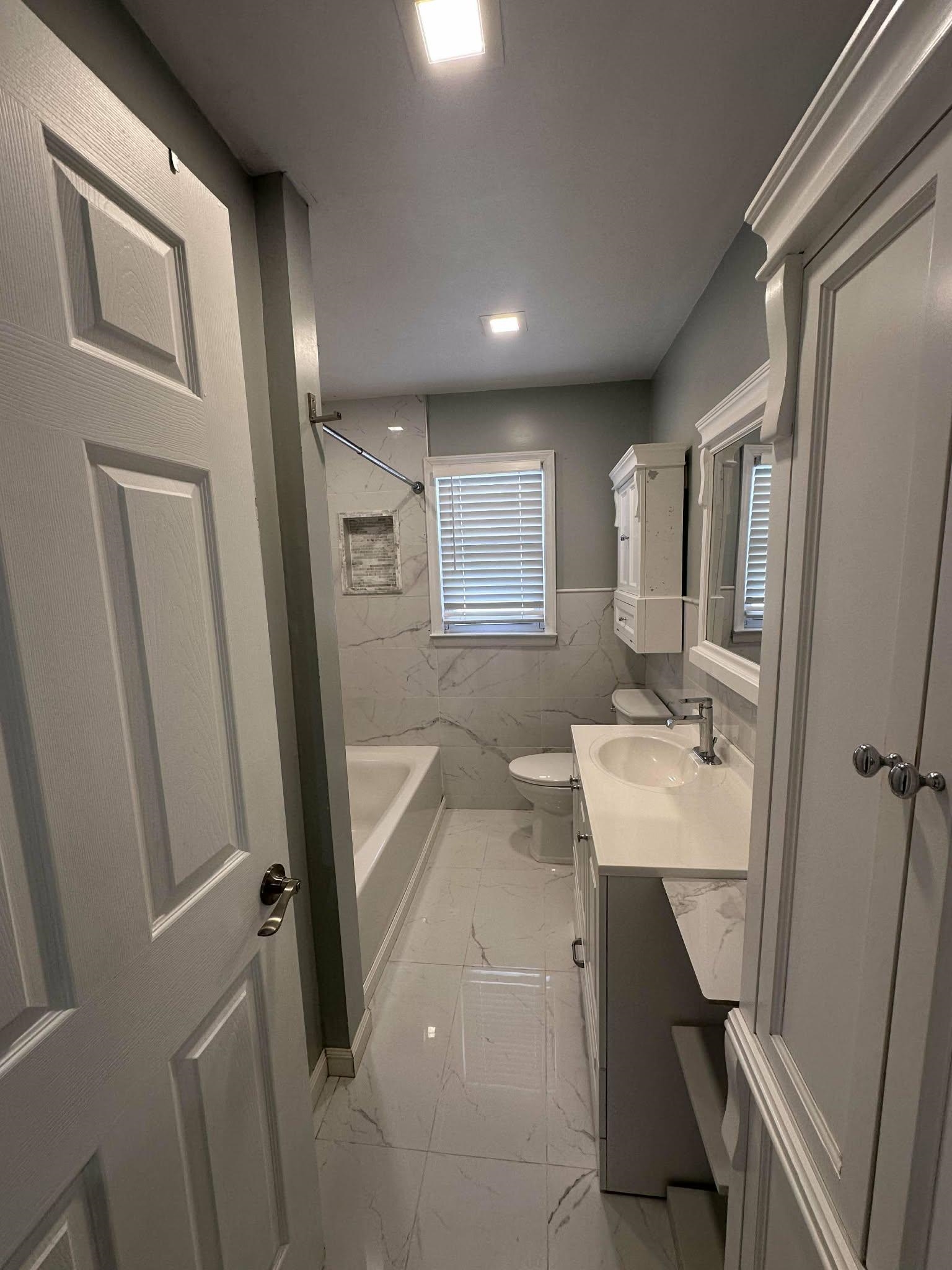 67 Country Village Road, Unit 2 Jersey City, NJ 07305 - Photo 6 of 20 a bathroom with a sink a toilet and a mirror