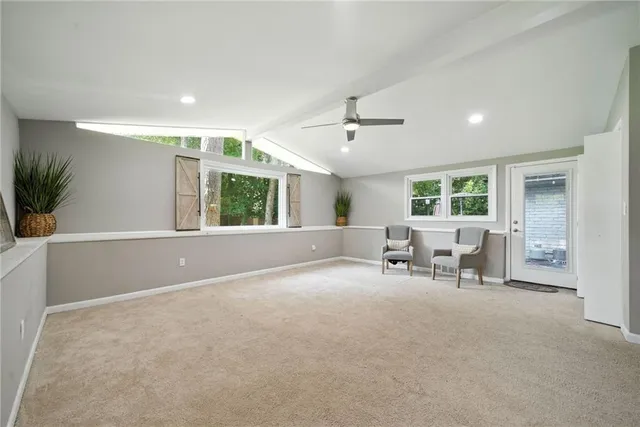 a view of an empty room with a window and chairs