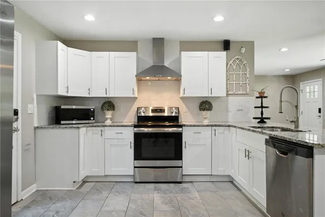 a kitchen with stainless steel appliances granite countertop a stove a sink and a refrigerator