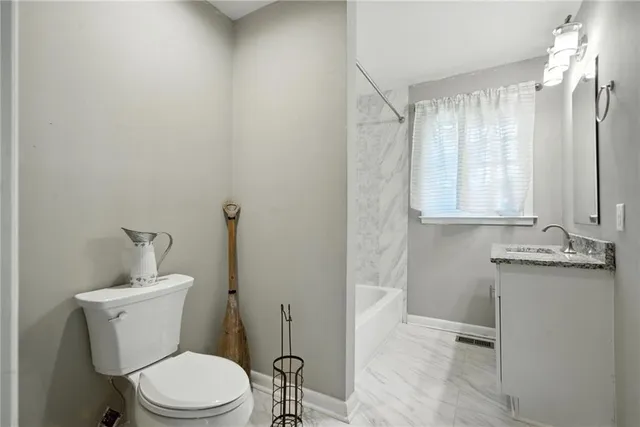 a bathroom with a toilet a sink and mirror