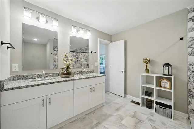 a bathroom with a granite countertop sink and a mirror