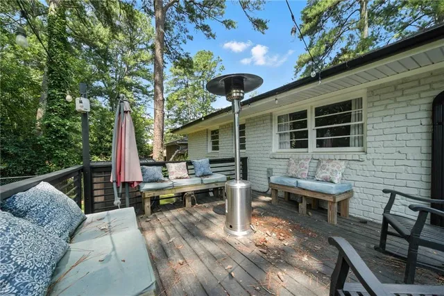 a view of a deck with table and chairs barbeque with wooden floor and fence