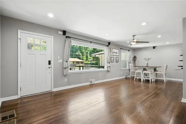 an empty room with wooden floor and windows