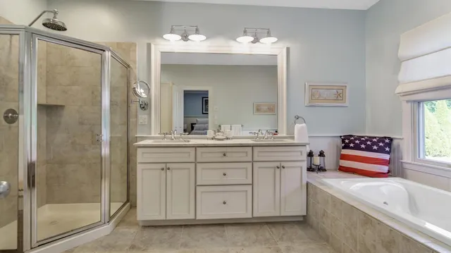 a spacious bathroom with a granite countertop sink mirror and a bathtub