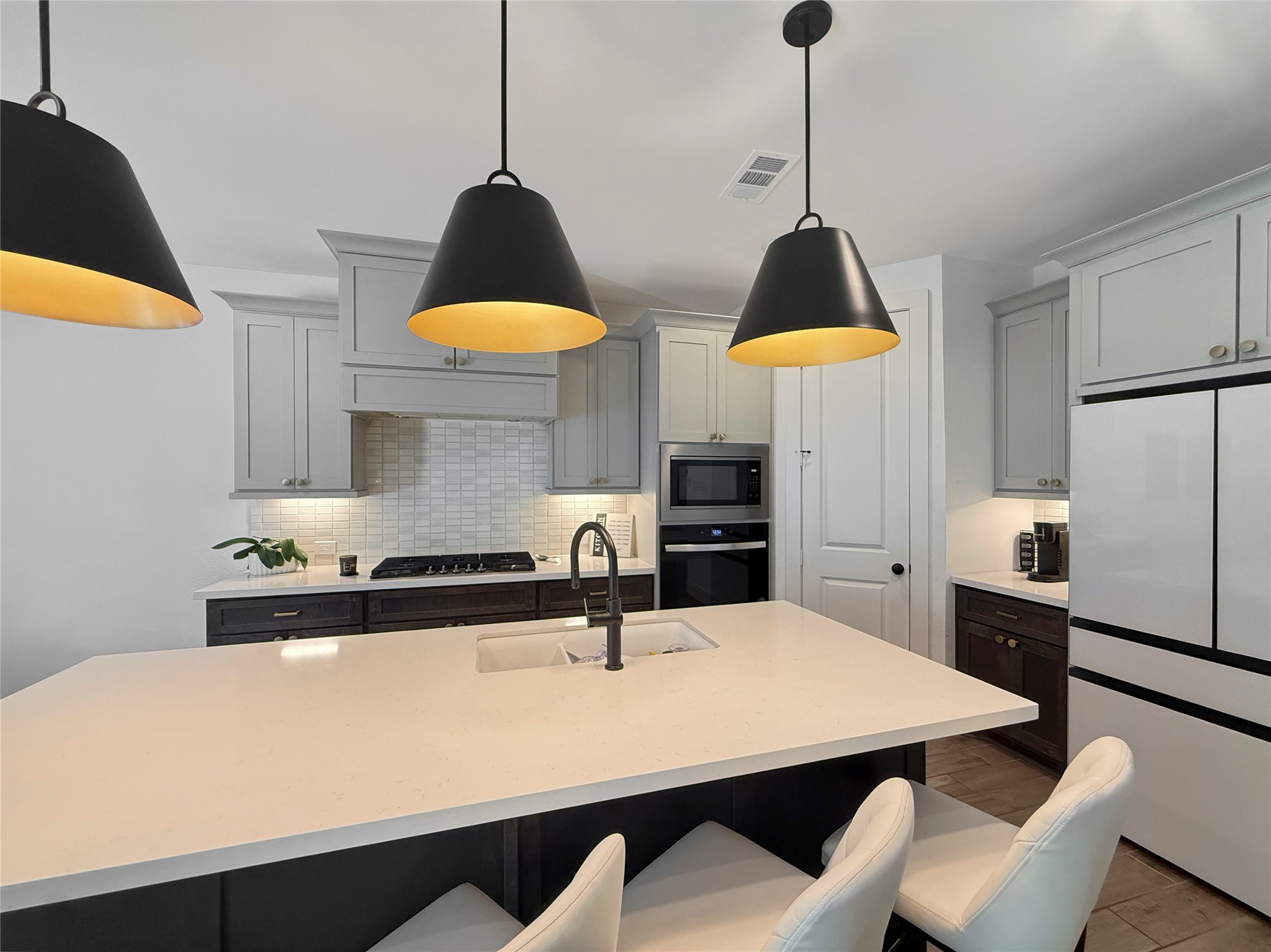 26918 Swanborough Road Spring, TX 77389 - Photo 15 of 50 The kitchen features additional coffee bar counter beneath eye-catching contemporary pendant lights.