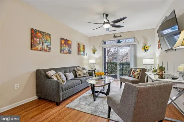 a living room with furniture wooden floor and a window
