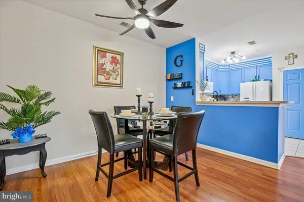 a dining room with furniture potted plants and wooden floor