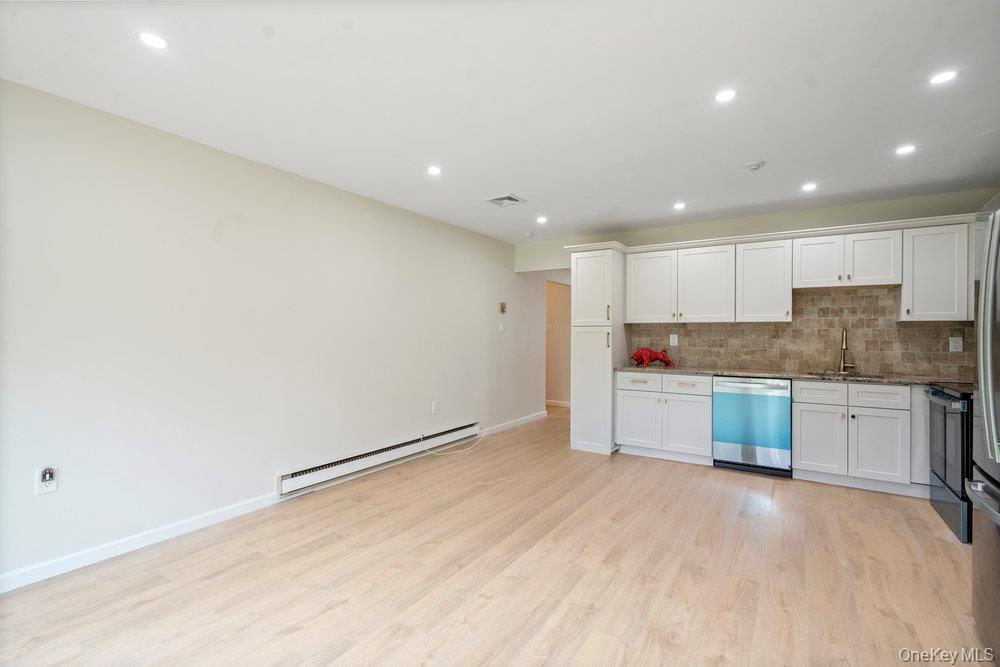 53 Freedom Lane Coram, NY 11784 - Photo 8 of 29 a large kitchen with a refrigerator a stove top oven a sink and dishwasher