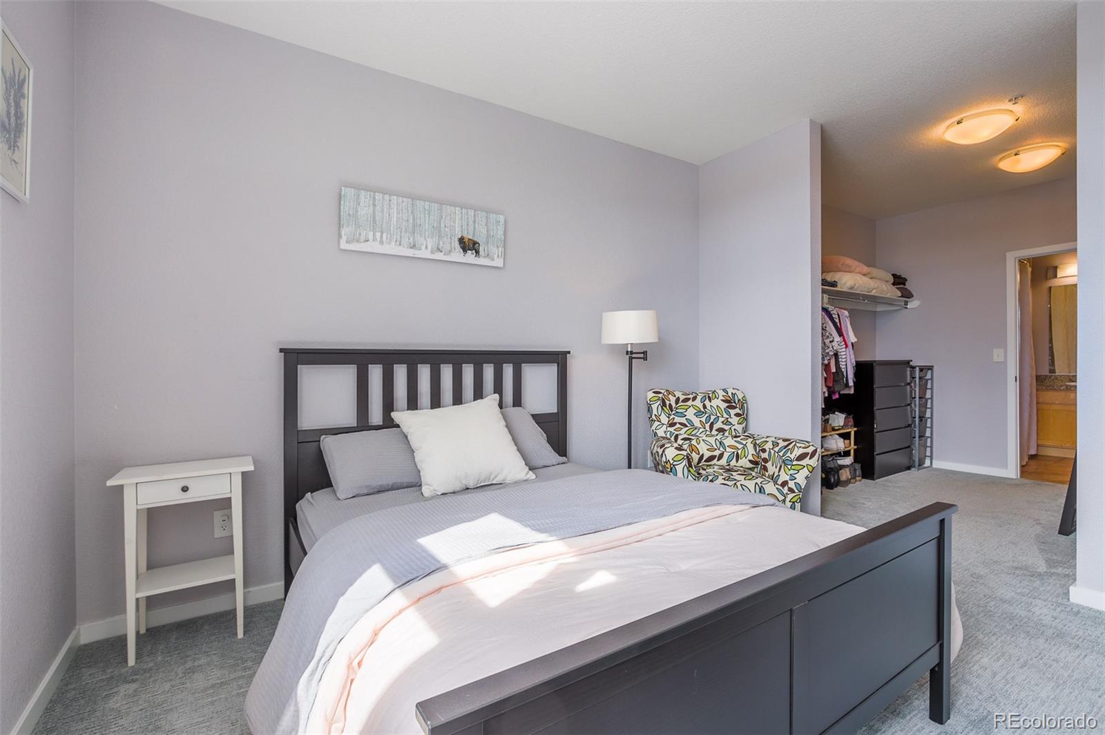 3101 Blake Street, Unit 305 Denver, CO 80205 - Photo 12 of 28 a bedroom with a large bed and a chandelier