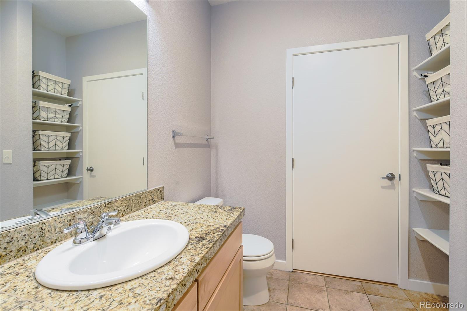 3101 Blake Street, Unit 305 Denver, CO 80205 - Photo 17 of 28 a bathroom with a granite countertop sink toilet and a mirror