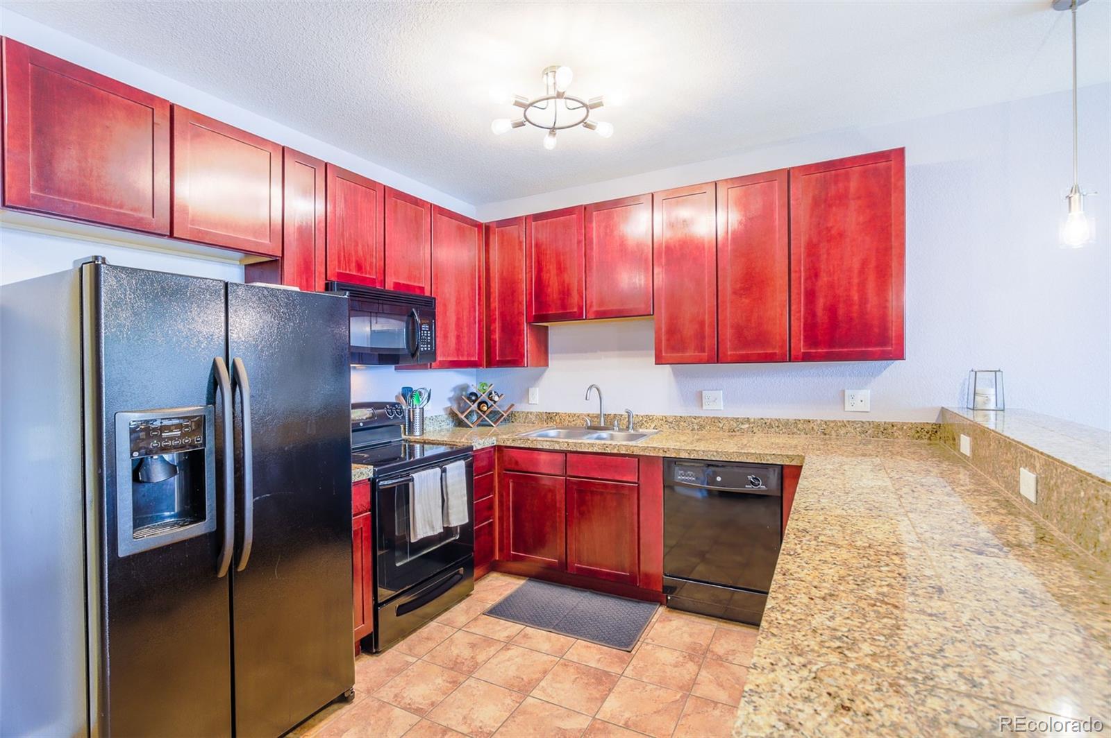 3101 Blake Street, Unit 305 Denver, CO 80205 - Photo 20 of 28 a kitchen with stainless steel appliances granite countertop a refrigerator a stove top oven a sink and dishwasher