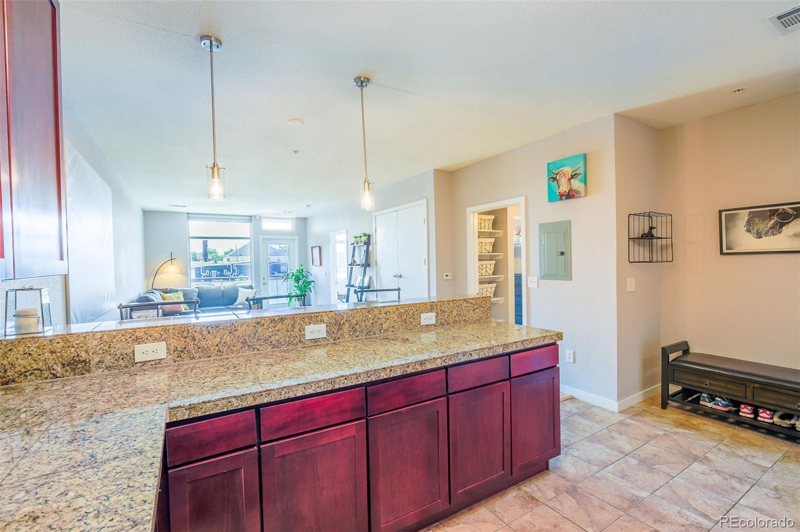 3101 Blake Street, Unit 305 Denver, CO 80205 - Photo 22 of 28 a view of a kitchen with kitchen island granite countertop wooden cabinets and a sink