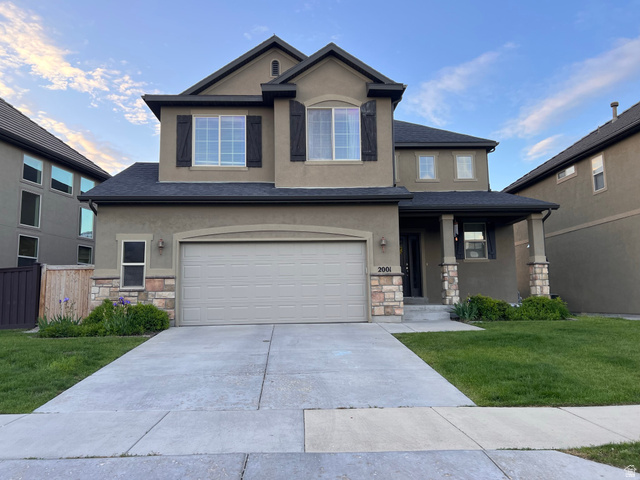 2001 Fielding Hill Lane Draper, UT 84020 - Photo 21 of 21 View of front facade featuring stone siding, a front yard, stucco siding, covered porch, and concrete driveway