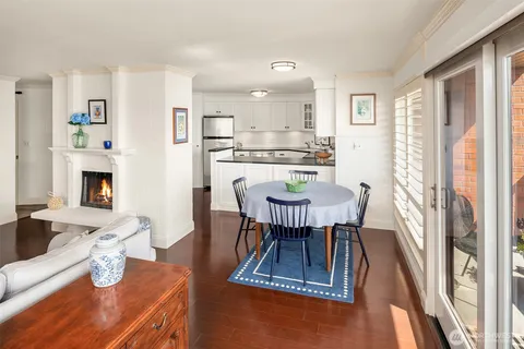 a dining room with furniture a rug a fireplace and a chandelier