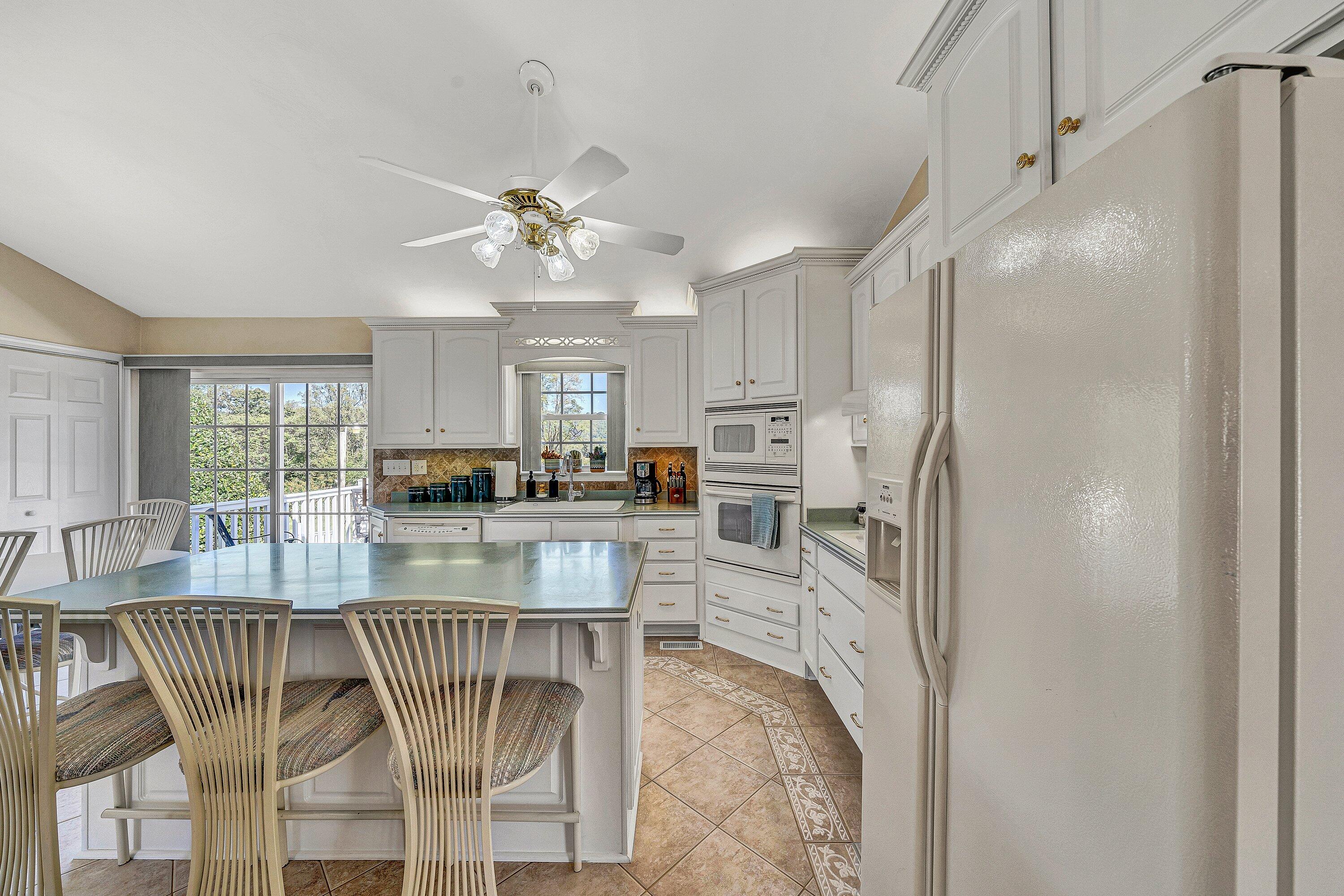 1850 Emmaus Church Road Moneta, VA 24121 - Photo 11 of 63 a kitchen with stainless steel appliances granite countertop a refrigerator a stove a kitchen island with a stove and white cabinets