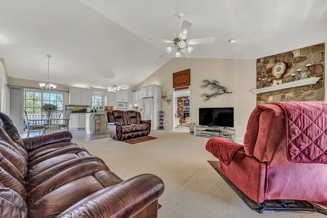 a kitchen with stainless steel appliances granite countertop a table chairs and chandelier