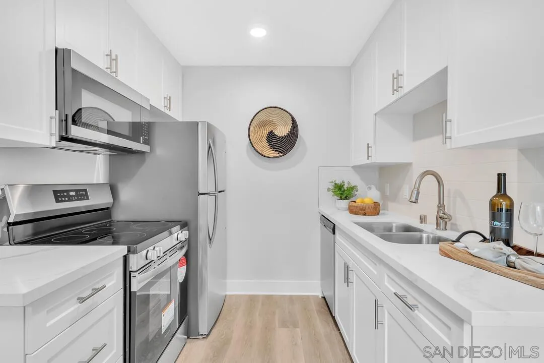 8644 Via Mallorca, Unit F La Jolla, CA 92037 - Photo 16 of 34 a kitchen with stainless steel appliances granite countertop a sink stove and cabinets