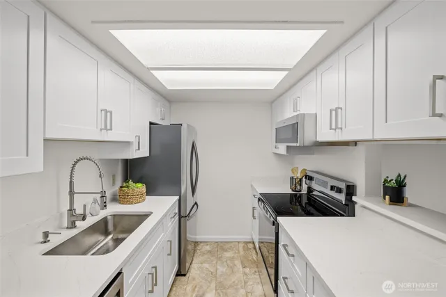 a kitchen with stainless steel appliances a sink a stove and a refrigerator