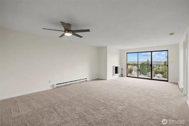 an empty room with windows and ceiling fan view