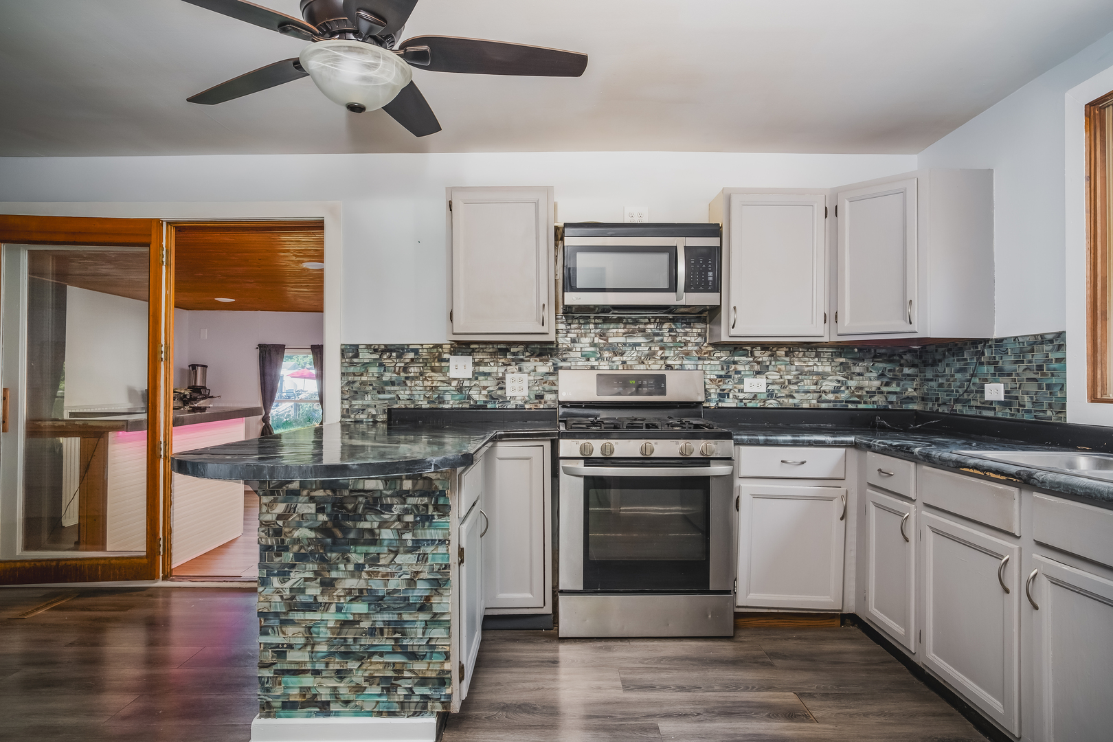 37902 North West Street Spring Grove, IL 60081 - Photo 12 of 26 a kitchen with stainless steel appliances granite countertop a stove top oven a sink and white cabinets