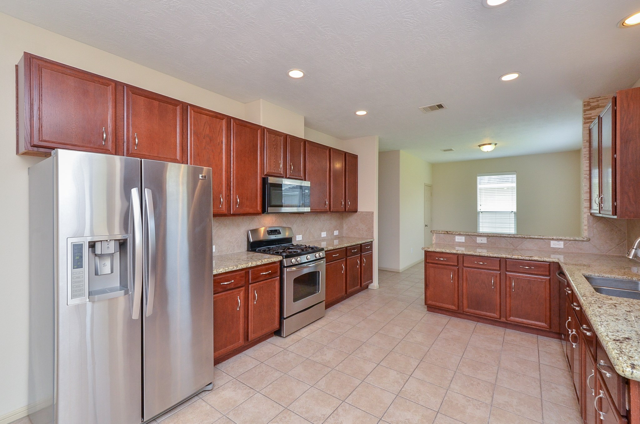 25135 Ginger Ranch Drive Katy, TX 77494 - Photo 8 of 32 Stainless steel appliances and a centered cooking area anchor this well-designed kitchen.