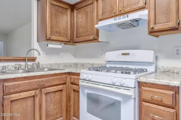a kitchen with granite countertop a sink stove and cabinets