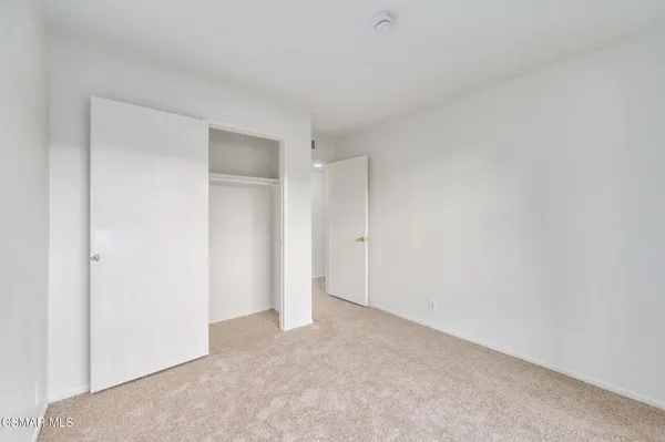 an empty room with windows and closet