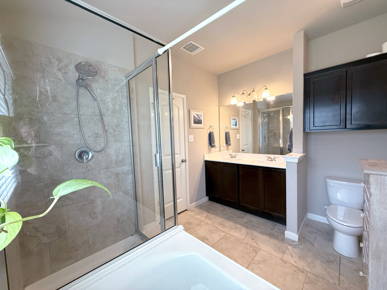 930 Pumpkin Ridge New Braunfels, TX 78130 - Photo 22 of 32 Bathroom featuring a glass-enclosed shower with stone-look tile surround and a separate tub