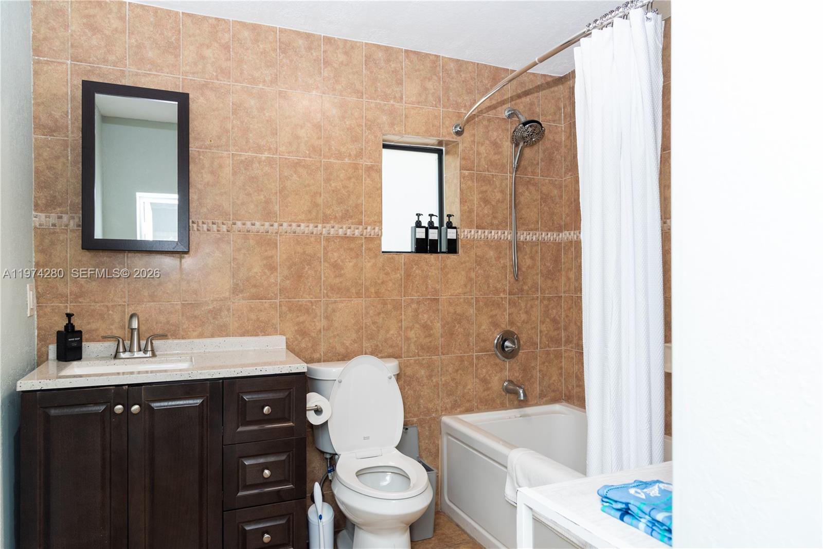 3134 Carter Street Miami, FL 33133 - Photo 16 of 36 a bathroom with a sink a toilet a mirror a bathtub and shower