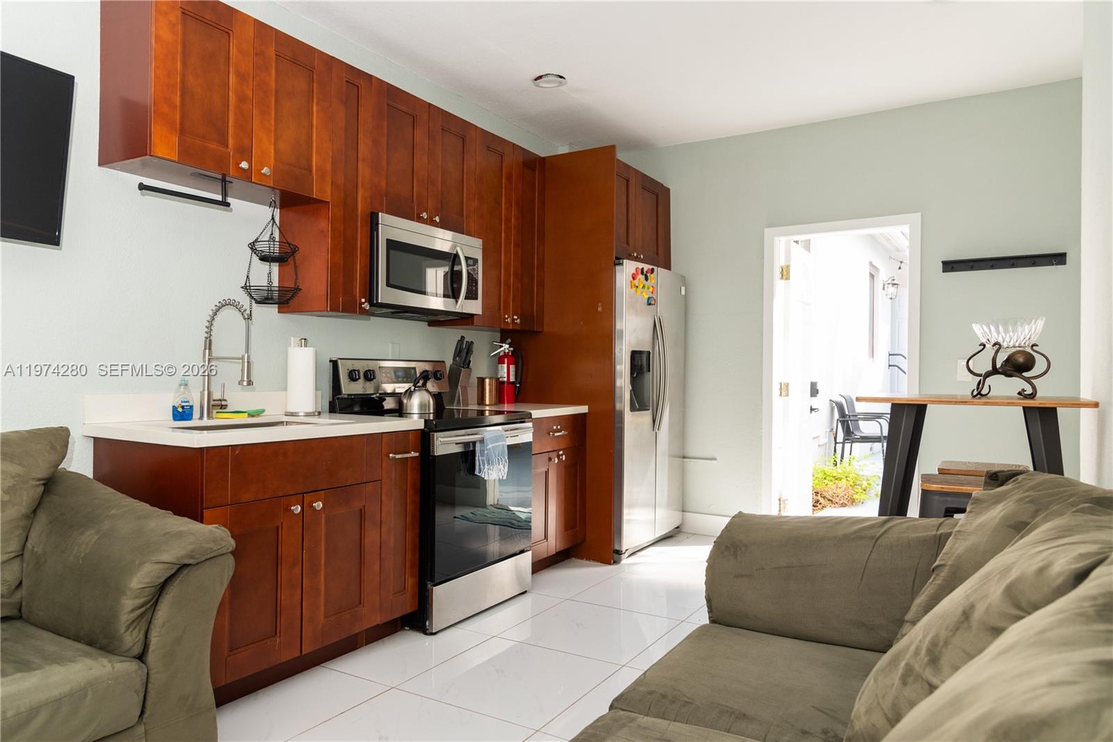 3134 Carter Street Miami, FL 33133 - Photo 17 of 36 a living room with stainless steel appliances granite countertop furniture a sink a refrigerator and a microwave
