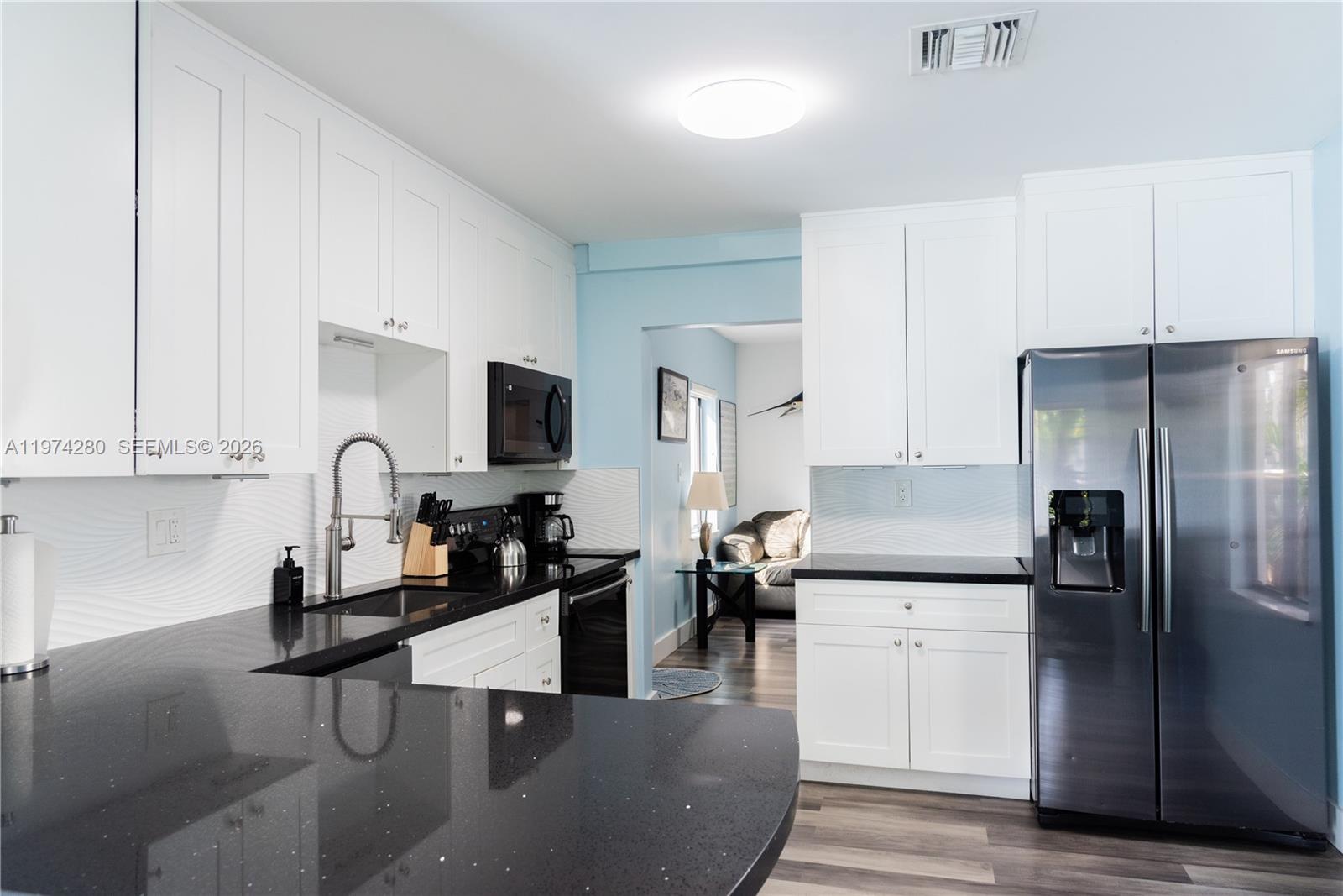 3134 Carter Street Miami, FL 33133 - Photo 30 of 36 a kitchen with stainless steel appliances granite countertop a refrigerator and a stove top oven